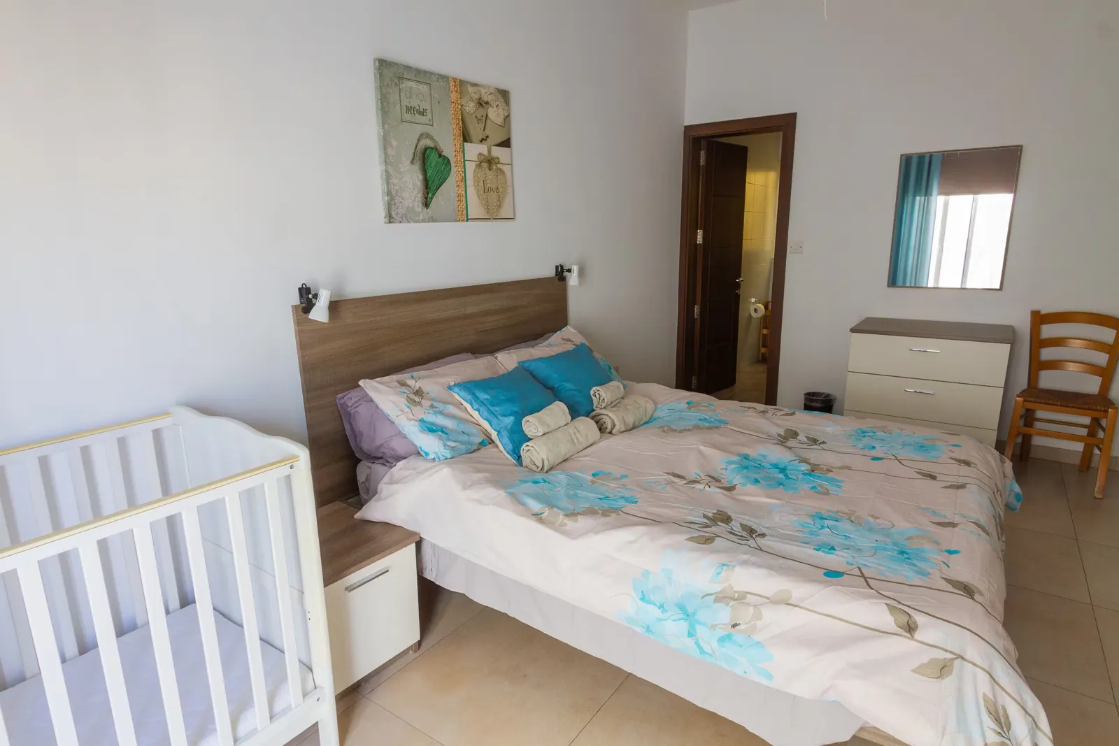 Main bedroom with queen bed and baby cot